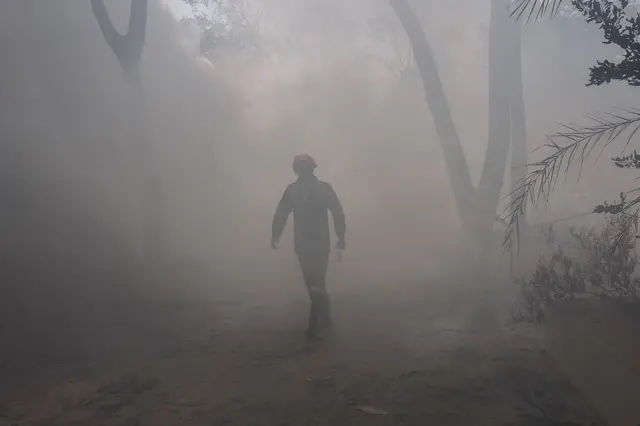 চারদিক কালো ধোঁয়ায় ভরে গেছে, তার মধ্যেই এক উদ্ধারকর্মী