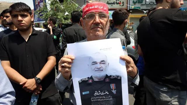 إيراني يحمل صورة قائد الحرس الثوري الإيراني، حسين سلامي، الذي قُتل في غارة جوية إسرائيلية، خلال احتجاج في طهران.