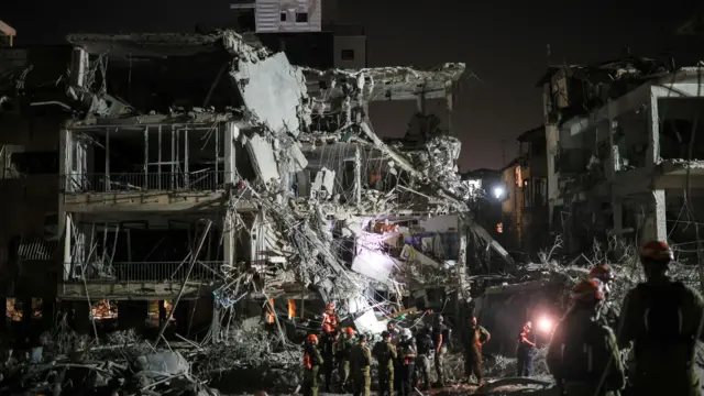 أفراد الإنقاذ والأمن في موقع هجوم صاروخي من إيران على إسرائيل، في رامات جان، إسرائيل، 13 يونيو 2025