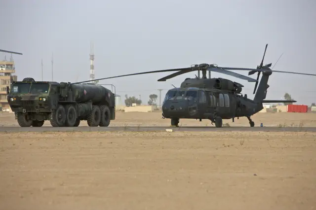 مروحية من طراز UH-60 بلاك هوك تابعة للجيش الأمريكي مع شاحنة التزود بالوقود في قاعدة سبايكر، تكريت، العراق.