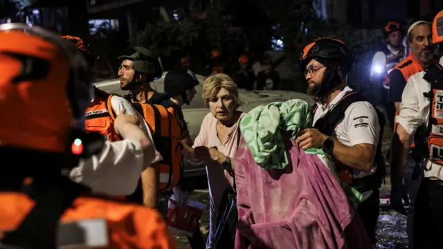 امدادگران در حال کمک به زخمی‌های حملات موشکی ایران در شهر ساحلی بت یام در استان تل‌آویو