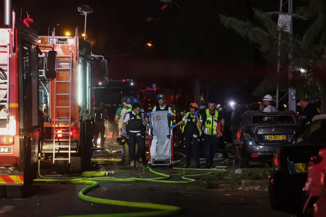 أفراد أجهزة الطوارئ والأمن الإسرائيليين في موقع أصيب بصاروخ إيراني في مدينة حيفا