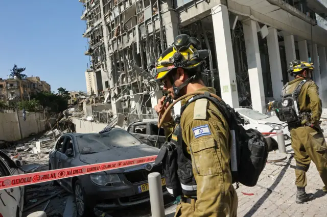 فرق طوارئ إسرائيلية تعمل في موقع هجوم صاروخي إيراني في رامات جان، وسط إسرائيل،
