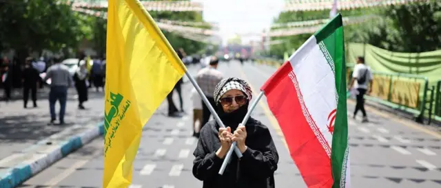 امرأة تحمل علمي إيران وحزب الله في طهران