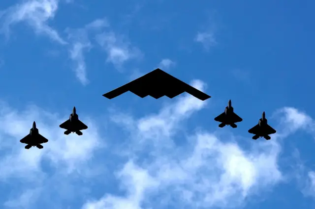 Бомбардировщик B-2 в сопровождении четырех истребителей