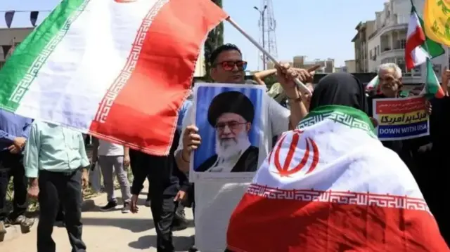 متظاهر يحمل صورة المرشد الأعلى علي خامنئي