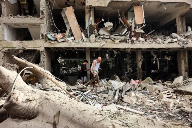 إخلاء السكان من موقع متضرر بعد هجوم صاروخي من إيران، وسط الصراع الإيراني الإسرائيلي في تل أبيب، إسرائيل، 22 يونيو/حزيران 2025.