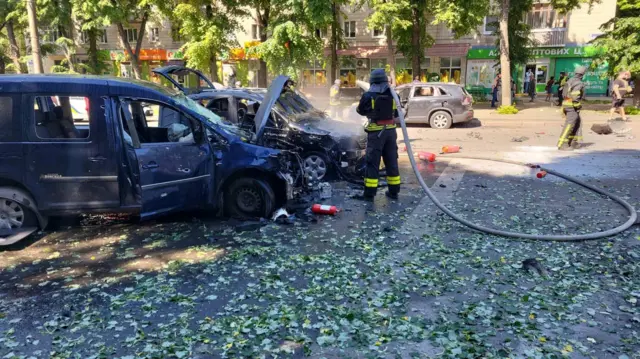 Сгоревшие машины и пожарный в Сумах.