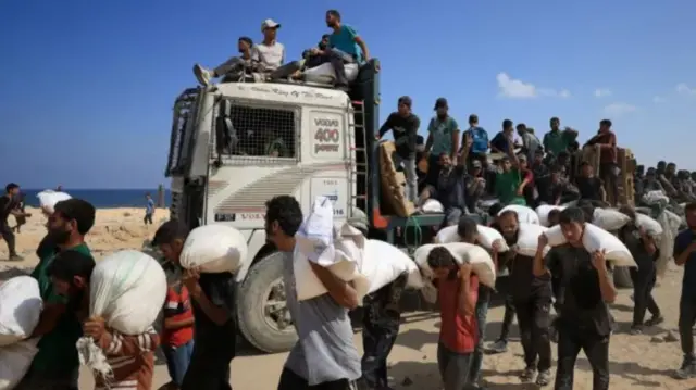 Ndị Palestine esetere na foto dịka ha bu ihe enyemaka na Beit Lahia, ugwu Gaza, na Sọnde
