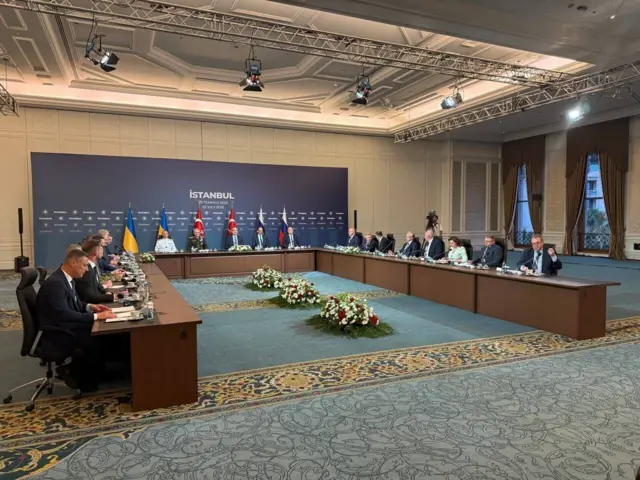 Делегации за длинным П-образным столом