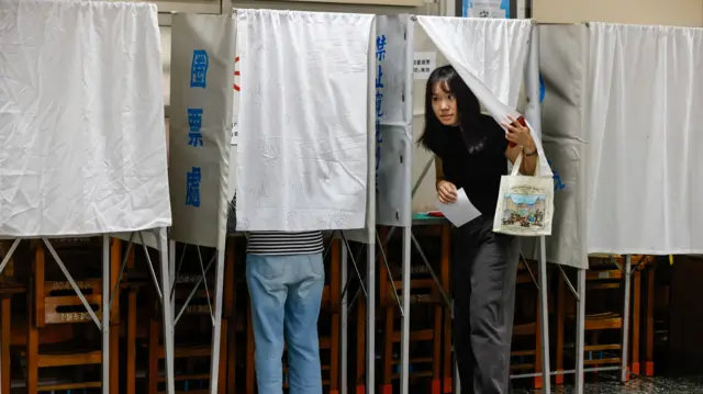 台灣「大罷免」台北大安建安國小投票站一位年輕女士離開圈票處（26/7/2025）