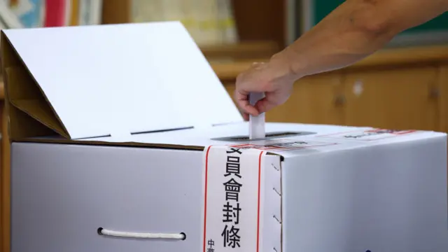 台北某投票站選民將「大罷免」選票投入票箱（26/7/2025）