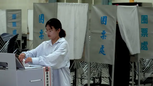 花蓮復興國民小學投票站一名女子將「大罷免」選票投入票箱（BBC中文圖片26/7/2025）