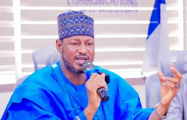 Gwamnan Katsina ke magana a zaune sanye da shuɗayen tufafi
