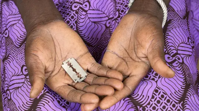 hoto reza a hannun wata sanye da tufafi masu launin cancan-bali, ɗaya daga cikin hannayenta sanye da warwaro