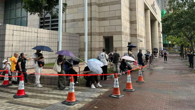 公眾人士持傘排隊旁聽黎智英案。