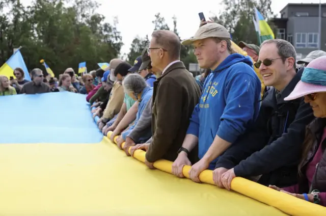 Учасники мітингу розгорнули великий український прапор після завершення саміту президентів
