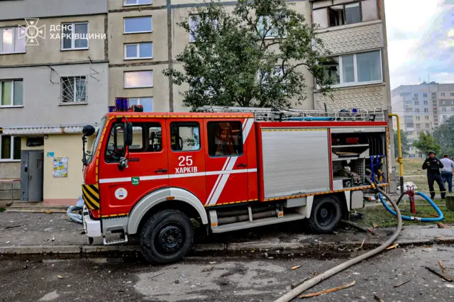 машина спасателей на фоне атакованного дома