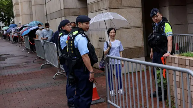 People queue to enter the West Kowloon Magistrates’ Courts building for the closing submissions in the national security collusion trial of Jimmy Lai, founder of the now-defunct pro-democracy newspaper Apple Daily, in Hong Kong, China, August 18, 202