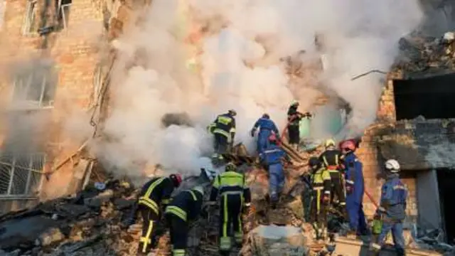 Wasu jami'an kashe gobara ke tsaka da aiki kan wani gini da ya rufta