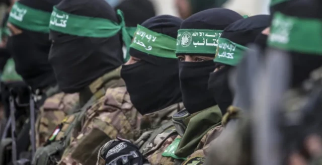 Foto faịlụ sitere na Febụwarị na-egosi otu ndịagha Hamas jiegbe n'oge a na-enyefe ndị Izrel eji eji