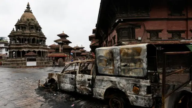 পাঠান দরবার স্কয়ারের কাছে বিক্ষোভকারীদের আগুনে পোড়া একটি গাড়ির ধ্বংসাবশেষ।