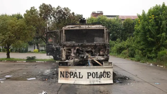 আন্দোলনকারীদের দেয়া আগুনে পুড়ে যাওয়া পুলিশের একটি যানবাহন