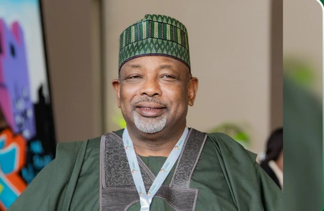Ministan noma sanye zaune a wani ɗakin taro