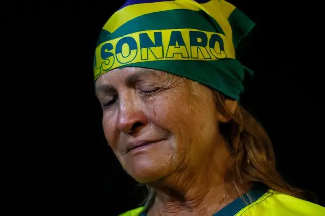 Mulher chora com bandana na cabeça escrito Bolsonaro