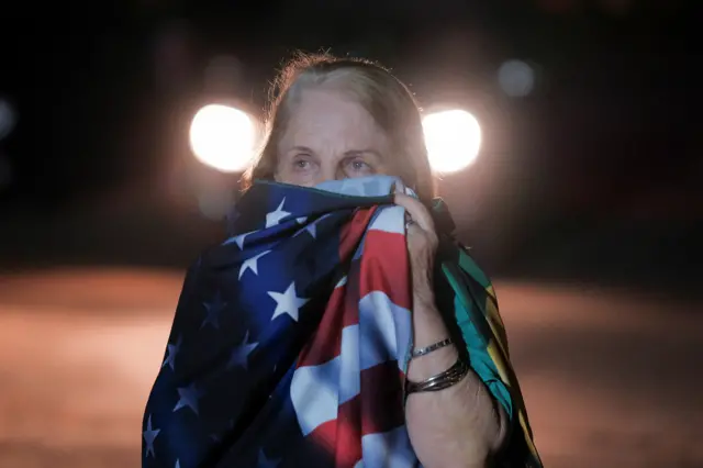 Mulher chora com bandeira dos EUA