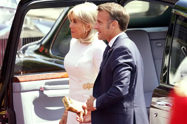 Onyeisiala mba Fransị bụ Emmanuel Macron na nwunye ya bụ Brigitte si n'ụgbọala arituta.