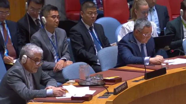 سفیر چین در سازمان ملل متحد. سمت راست او نمایند ایران است که در جلسه امروز شورای امنیت شرکت کرده است