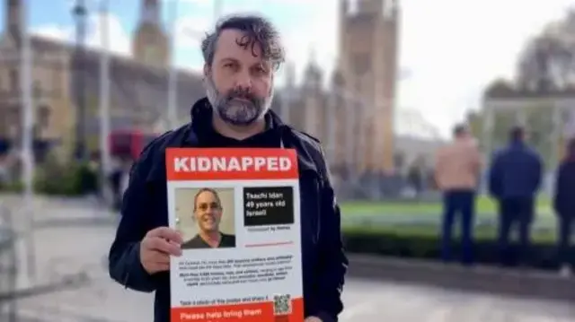 أحد أقارب الرهائن الإسرائيليين يحمل صورة له.