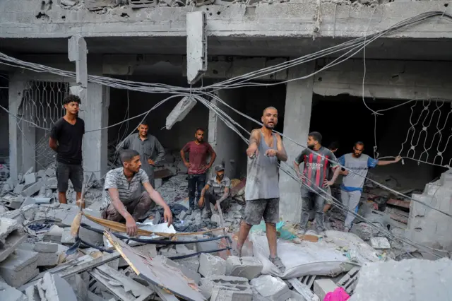فلسطيني أثناء تفقده موقع الغارات الإسرائيلية على منازل في مخيم الشاطئ للاجئين، وسط عملية عسكرية إسرائيلية، في مدينة غزة، 23 سبتمبر/أيلول 2025.