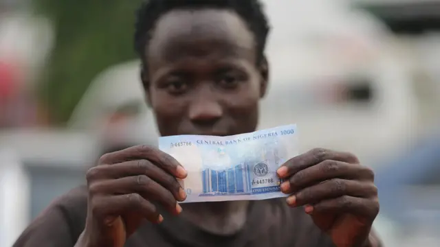 Wani mutum riƙe da naira