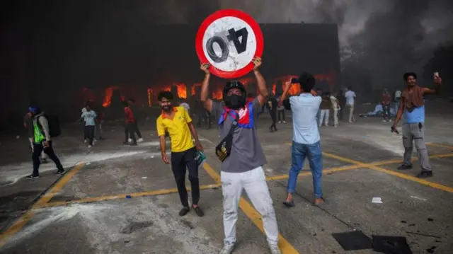 সংসদ ভবনের ভেতরে আগুন লাগার পর বিক্ষোভকারীরা বাইরে উদযাপন করেন