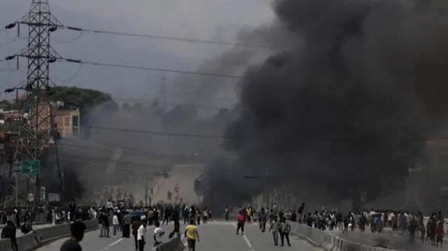 রাস্তায় বিক্ষোভকারীদের ও ধোঁয়া জ্বলতে দেখা যাচ্ছে