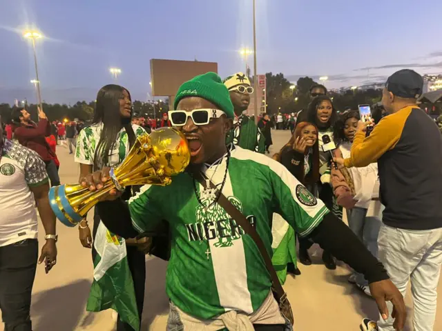 E wear Nigeria national green and white jersey wit green winter cap and white sunglasses
