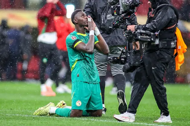 Moussa Niakhate na Senegal da gwiwoyinsa a ƙasa yana godiya