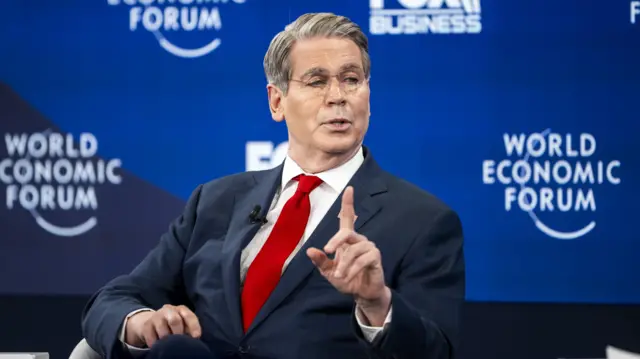 اسکات بسنت، وزیر دارایی آمریکا نشسته با کت سورمهای، پیراهن سفید و کراوات قرمز