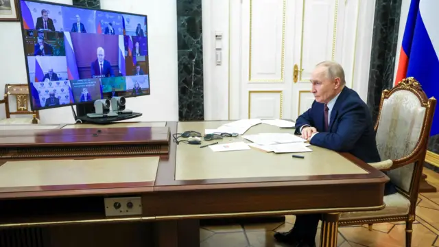 Владимир Путин сидит один перед экраном с окнами видеосвязи