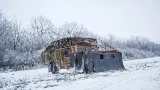 Хамви стоит на снегу накрытый противодроновой сеткой