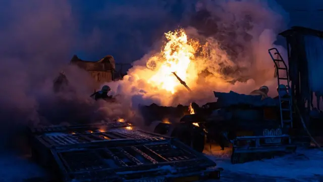 कीएव में हवाई हमले वाली एक जगह पर आग बुझाते यूक्रेन के इमरजेंसी कर्मी