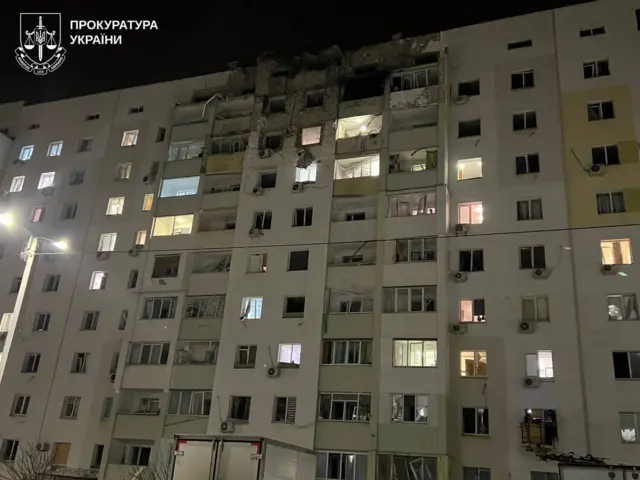 Многоэтажный дом, в верхние этажи которого попал снаряд.