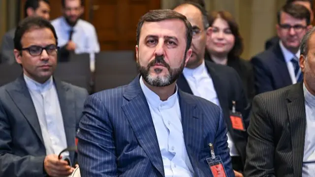 کاظم غریب‌آبادی با کت آبی راه‌راه و پیراهن سفید نشسته در محمع سازمان ملل