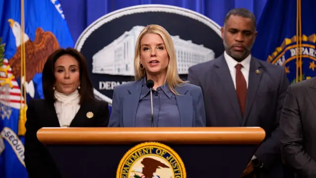 Imagen de Pam Bondi en un podio, flanqueada de varios funcionarios.