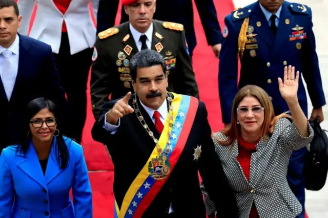 Maduro, a esposa e a vice-presidente da Venezuela acenando