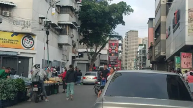 Pedestres e motociclistas em rua de Caracas