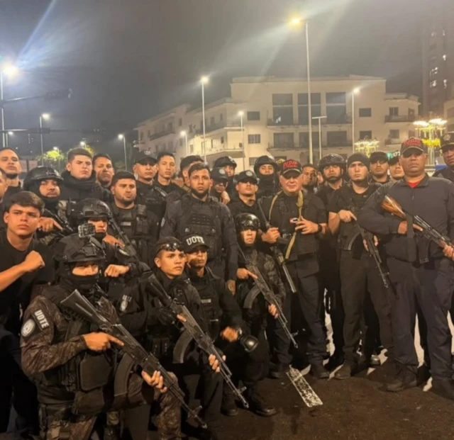 Cảnh sát vũ trang tuần tra các đường phố ở Caracas trong đêm. Bộ trưởng Tư pháp Diosdado Cabello đội mũ đen chữ đỏ đứng gần trung tâm