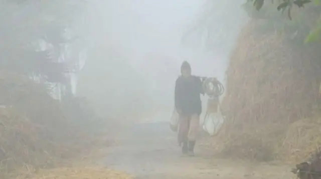 ঘন কুয়াশার মধ্যে একজন ব্যক্তি হেটে আসছেন